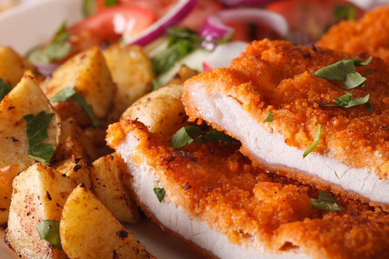 Knuspriges Schnitzel mit Bratkartoffeln und frischem Salat als traditionelles Mittagsmenü in einem Restaurant in Herzogenburg.