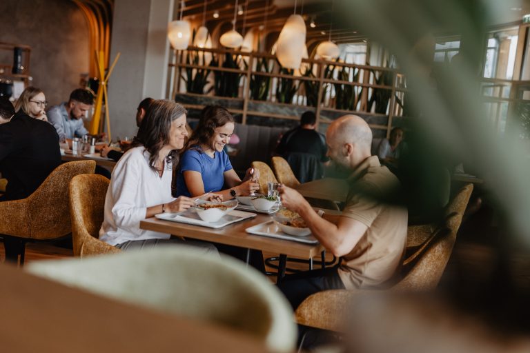 Restaurant in Herzogenburg mit Gästen beim gemeinsamen Mittagessen in modernem Ambiente und gemütlicher Atmosphäre.